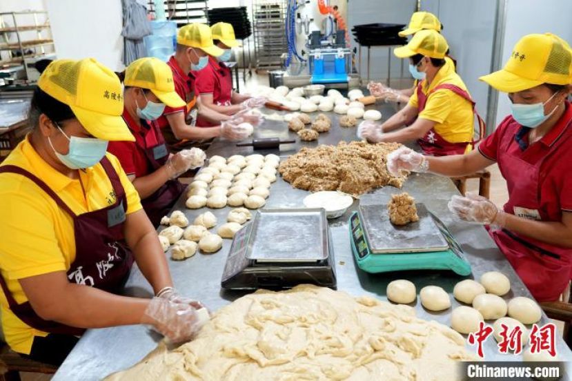 师傅们正忙着制作传统手工月饼，馅料调配、和面、包馅、压模。