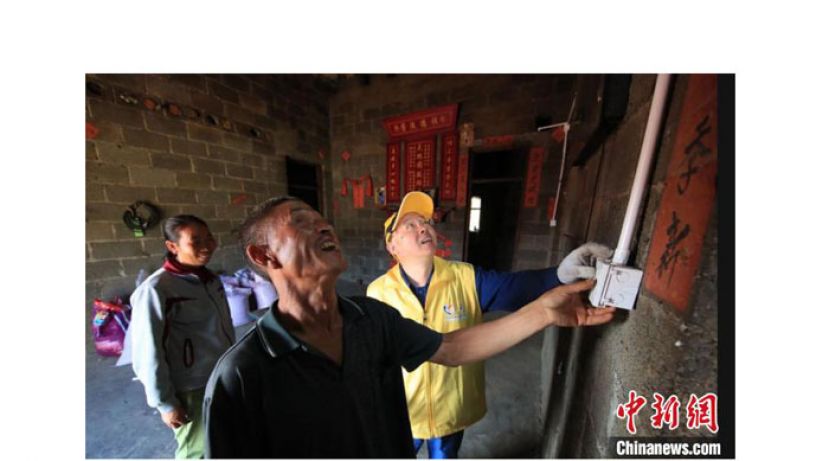 钱海军在贵州为当地残疾贫困家庭免费改造照明线路。