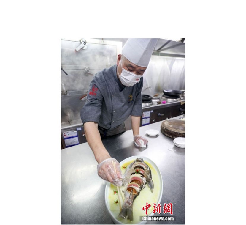 第四代武昌鱼传承人、鄂州长城V酒店主厨施建军制作清蒸武昌鱼。