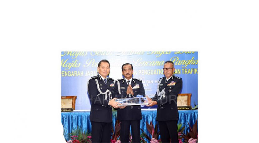 拿督阿兹曼（右起）在警察总长丹斯里拉查鲁丁见证下，从该局代总监拿督莫哈末纳斯里手中，接过武吉阿曼交通调查及执法局总监一职。