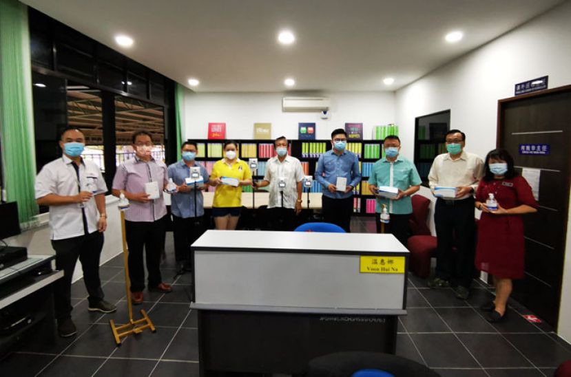 三小热心家长郑志国（左三）、沈佩赪（左四）移交抗疫物品予古晋中华小学校董会主席拿督王长福（右五），右一为三小校长朱珍妹。