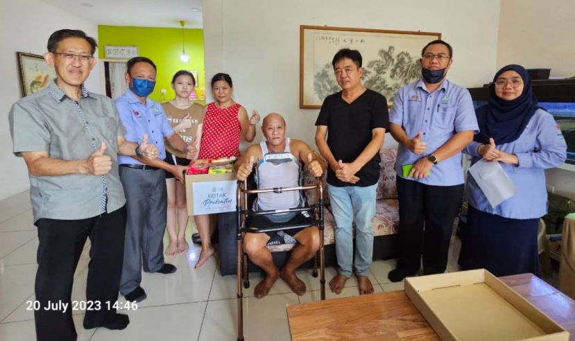 社险砂局长陈邦正（左2）移交物资给自雇人士投保何姓伤者并予慰问；左为坊间社险福利觉醒协调员薛华东（左）及许义华（右3）等人。