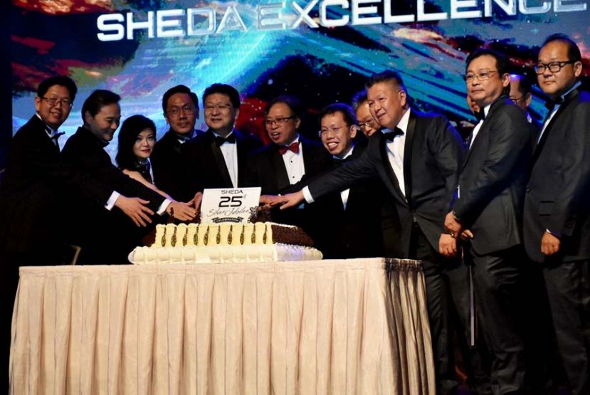 图一:拿督巴丁宜阿邦佐哈里(中)在砂房地产发展商会理事会陪同下共切25周年纪念蛋糕。