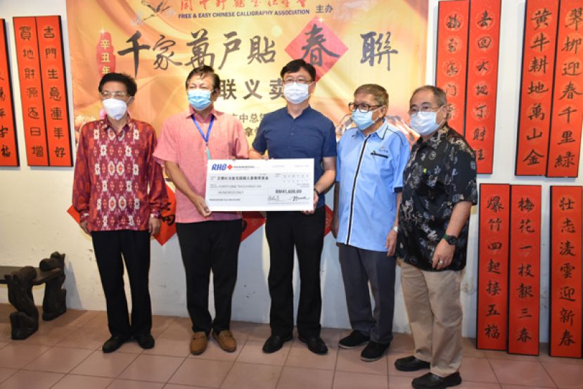在中国驻古晋总领事程广中（左一）的见证之下，总赞助人拿督王长福（左二）移交义款予卫理杜当堂无国籍儿童教育基金吴高文（右  三），右一为闲云野鹤书法学会总顾问蔡振强及会长杨添木。