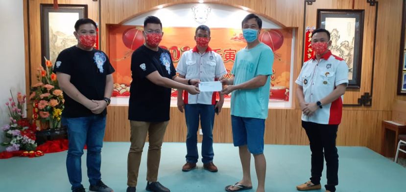 在会长周文盛（中）和福利股及墓山保管委员会主任陈实福（右一）的见证下，古晋潮州公会青年团署理团长沈茂前（左二）颁发《潮宝  生育奖励金》之奖励金予申请合格的刘绵杰（右二）。左一为青年团团长黄伟忠。