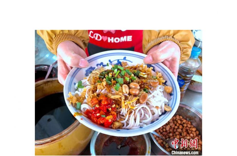 江西南昌秦坚红的老店里，店员展示一碗刚制作好的南昌拌粉。在拌粉的调料台上，总有一盆不起眼的辣椒酱。