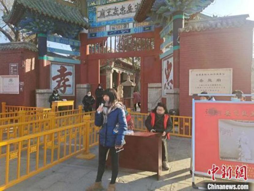 一名游客在岳飞纪念馆门前背诵《满江红》。