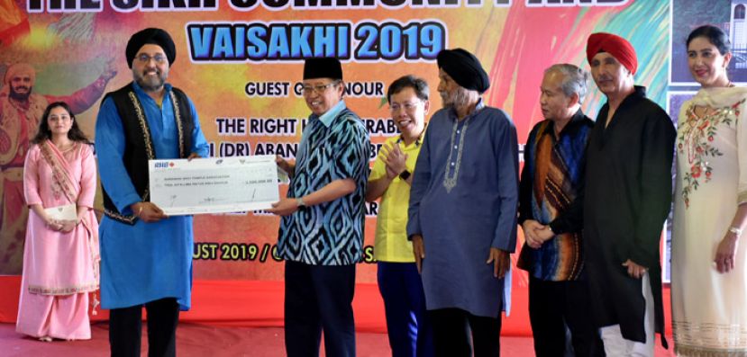 砂首长阿邦佐哈里移交350万令吉拨款，由古晋锡克庙古主席凯威特星凯拉（左二）接收