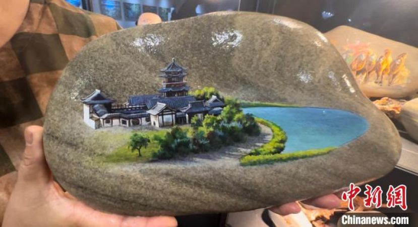 马玉兰展示鸣沙山月牙泉石艺画作品。