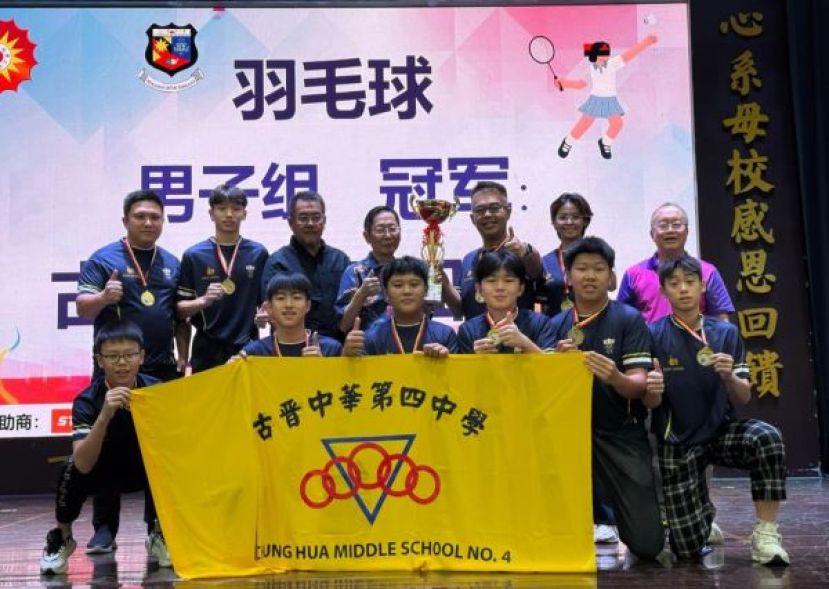 砂华文独中董联会主席天猛公拿督刘利民（后排中）移交男子组羽球冠军奖杯给四中校长官晨阳，并与全体球员合照。