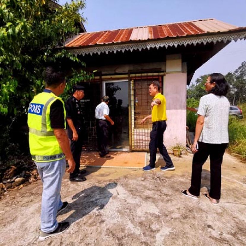 砂首长署政治秘书陈开（右二）与警官到石角路居民住家了解犯罪案的情况。