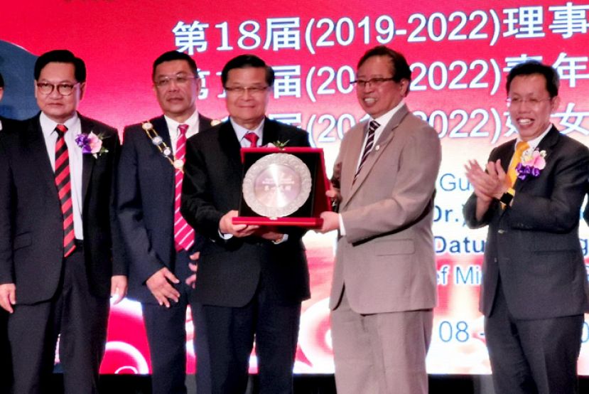  砂华总永久名誉会长拿督许德忍（左三）从首长阿邦佐哈里（右二）手中接过纪念品。