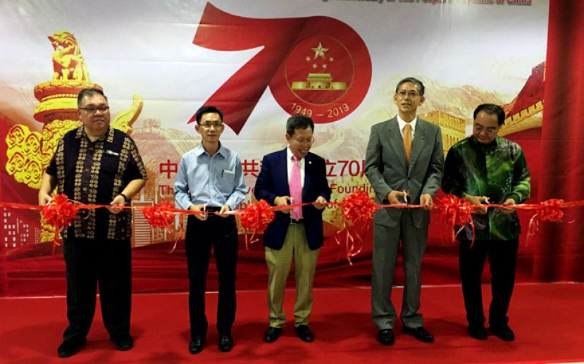 中国庆祝成立70周年主题国际巡展（古晋站）剪彩开幕式。中为砂地方政府与房屋部部长拿督沈桂贤和中国驻古晋代总领事张阳(右2)，左1为国际时报董事经理兼总编辑拿督黄国辉。