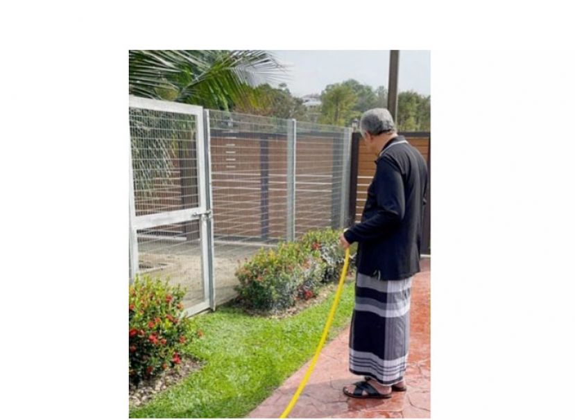 阿末扎希在脸书上贴在庭院浇花照片。