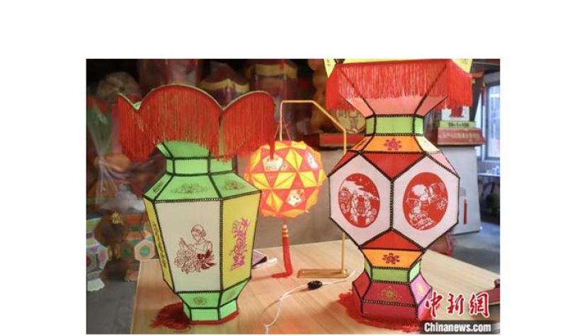 两盏采用传统宫灯造型的彩扎灯定格着抗疫一线的动人画面。