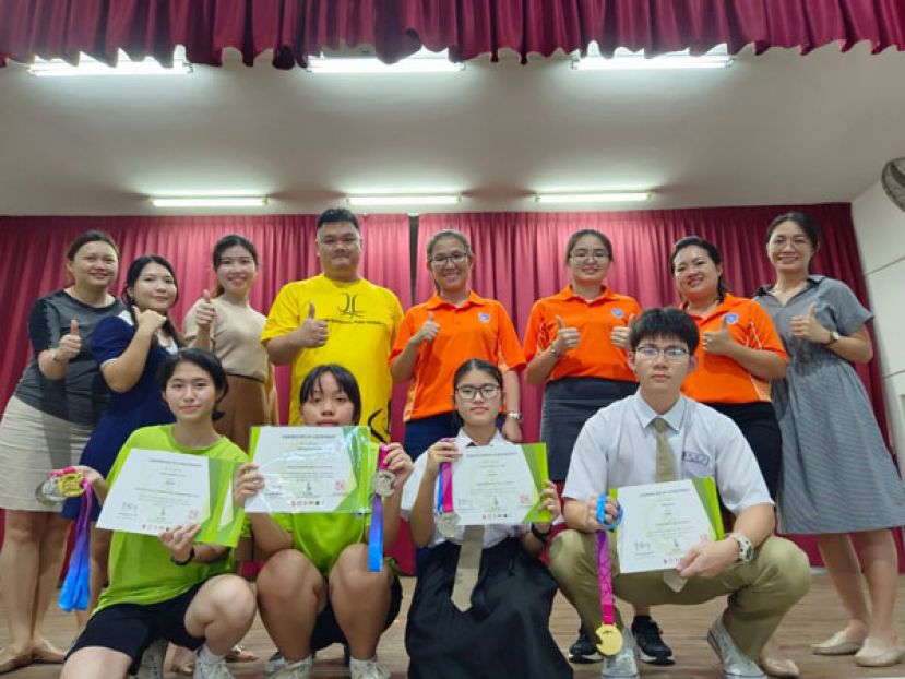 获奖者与该校行政主任及学会导师合影。             前排左起：梁宇涵、李家琴、王思语、林新杰。后排左四：黄国伦武术教练。