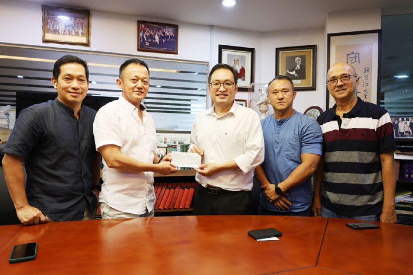 实旦宾区国会议员兼浮罗岸区州议员张健仁（中）在众人的陪同下，即席移交5000令吉的拨款支票给哥打巴达旺捷兔俱乐部大会主席沈瑞鹏（左2）。左起为筹委会主席毛维清；右起为俱乐部纠察陈永泉及会员陈国宝。
