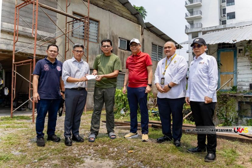 拿督阿都拉赛多（右三）见证下，砂拉越公关单位总监阿旺普特拉尤斯里阿旺雷祖安（左二）移交移交援助金予住家因狂风暴雨受损的英文报摄影记者Chimon Upon。
