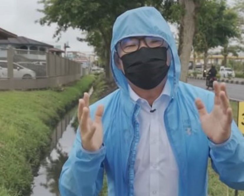 砂政盟人联党候选人程明智冒旺大雨巡察柏拉区排水系统的沟水流量。