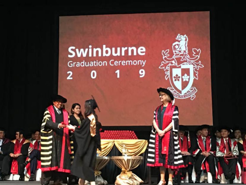 砂首长阿邦佐哈里（左）颁发证书予其中一名毕业生。