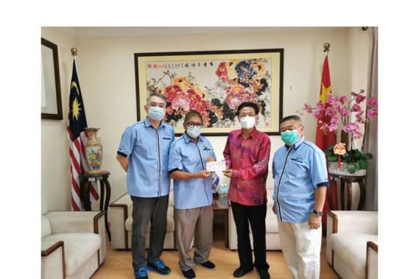 中国驻古晋总领事程广中（右二）移交赞助款予闲云野鹤书法学会会长杨添木。在场者包括闲云野鹤书法学会理事刘志汉（左一）及李汉标（右一）。