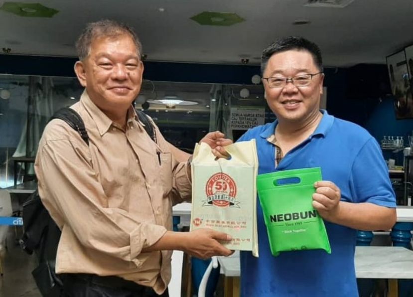 陈中兴（左）由中发药业负责人陈德发手中接过赞助义诊的脱苦宝药贴。