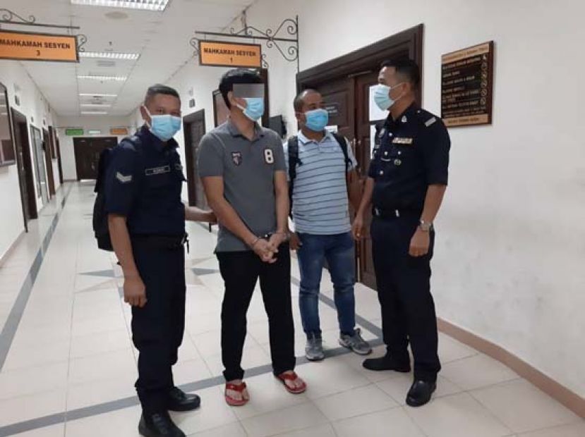 涉嫌引入非法外劳的被告（左二）在庭外等候过堂。