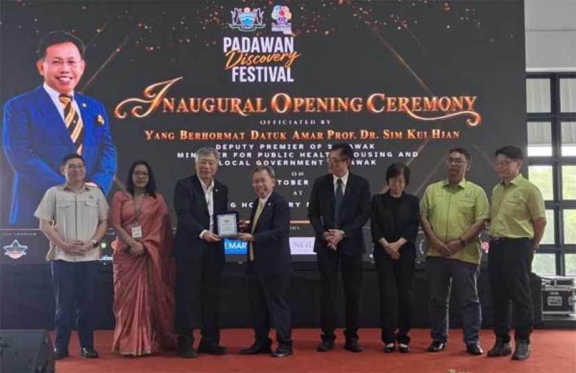 在众嘉宾的陪同下，砂拉越厂商联合会会长蔡美星（左三）赠送纪念品予主宾拿督阿玛沈桂贤时影。