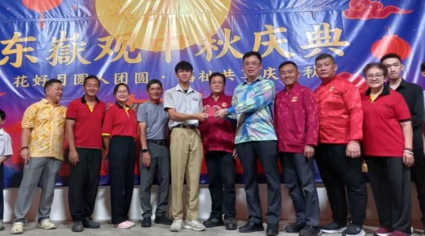 主宾巴达旺市议会主席陈开（右5）在古晋东嶽观主席方文祥太平局绅（中）与理事陪同下颁发学子荣誉奖。左4为该观署理主席方明生。