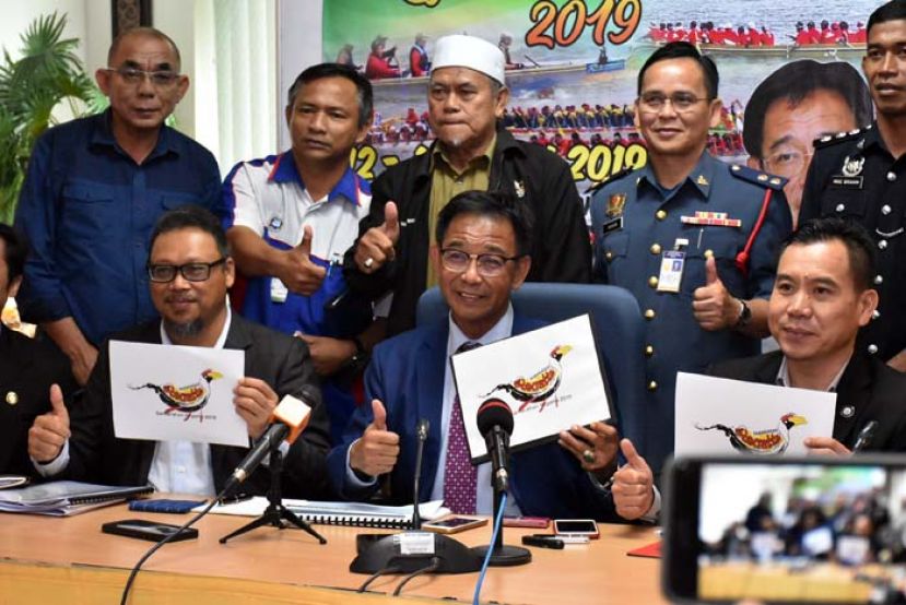 砂旅游、艺术、文化、青年与体育部长拿督阿都卡林（前排中）展示三马拉汉赛船盛会宣传单。