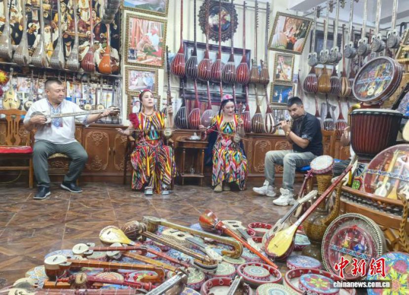 新疆喀什古城居民弹奏乐器，气氛欢快。