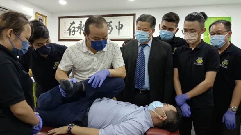 砂医总会长兼亚洲中医技职学院院长江宗兴（右3）观摩程广庆老师（左3）为学员指导整骨。