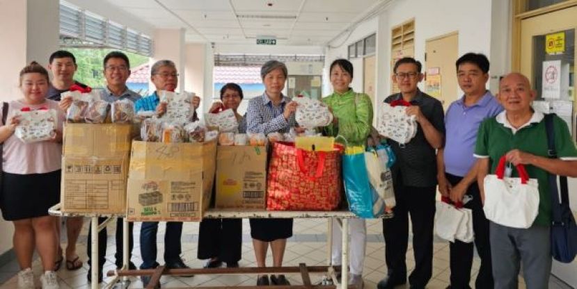 古晋慈爱社区关怀协会负责人黄慧芬（右4）将赠留医孩童礼物及给留守家长的干粮食品移交砂中央医院院长严慧文医生。右起为田昭炎、许义华、薛华东；左起是官怡穎、佘紹正、刘添闹、郑李金春伉俪。