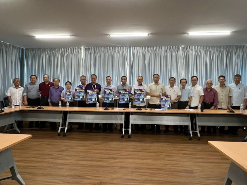 晋汉连省华人社团总会、古晋中中校董会与中国银行代表手持反诈骗讲座活动海报合影，齐心推动社区与校园金融安全教育。左起：古晋中中校董会副视察甲必丹锺忠、古晋中中校董会副财政王运才博士、古晋中中校董会副秘书何晋兴、古晋中中校董会监学翁岳春、三中校长林会颖、四中校长官晨阳、一中校长李志鹏、中国银行古晋分行行长贾郧建、古晋中中校董会主席兼晋汉连省华总会长拿督黄良杰、晋汉连省华总副会长高伟宁、古晋中中校董会秘书长关伟华、晋汉连省华总秘书长林亚德、古晋中中校董会副主席郑佑上、晋汉连省华总副会长陈瑞光、古晋中中校董会监学何健赞、古晋中中校董会副主席沈楚鹏、古晋中中校董会视察罗国华。
