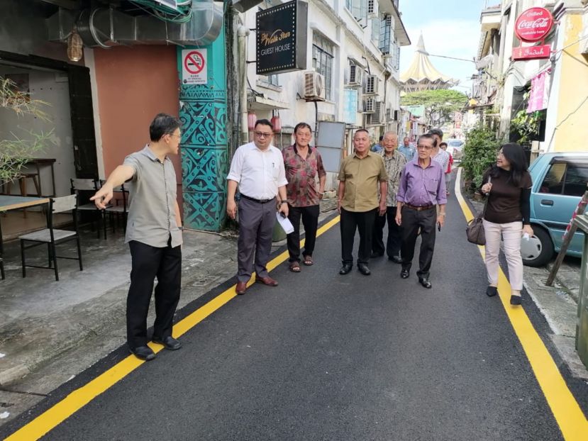 薛华东（左起）、北市工程师扎迪、林顺理、甲必丹林传政、沈云豹、本固鲁陈兴枝、甲必丹许碧珠等人巡视老巴刹区道路重铺沥青工程。