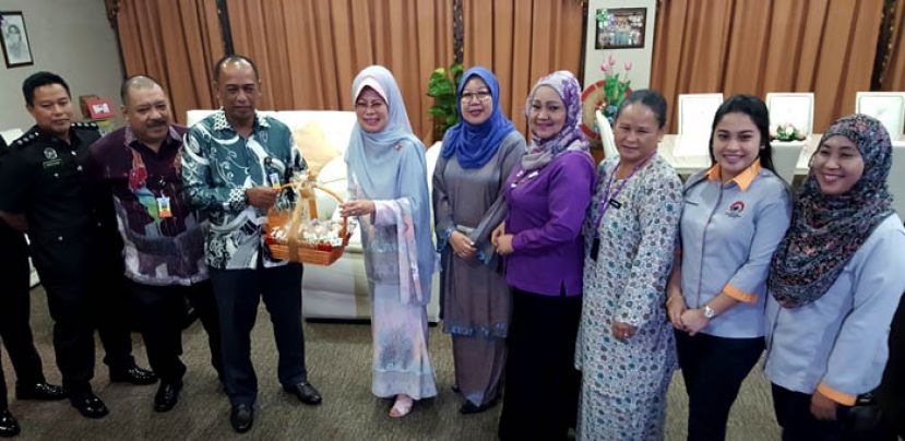 砂监狱局局长阿基丁沙雷（左三）在众人的陪同下，赠送纪念品给砂福利、幸福社区、妇女、家庭与儿童发展部拿督斯里陈赛明。