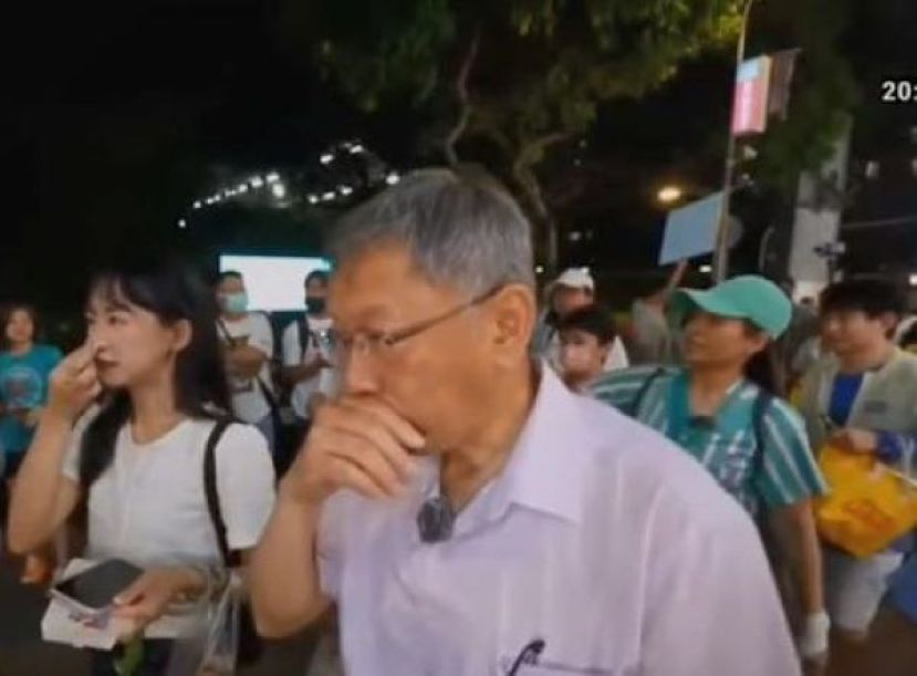 柯文哲手遮住鼻子，表情略有不适。