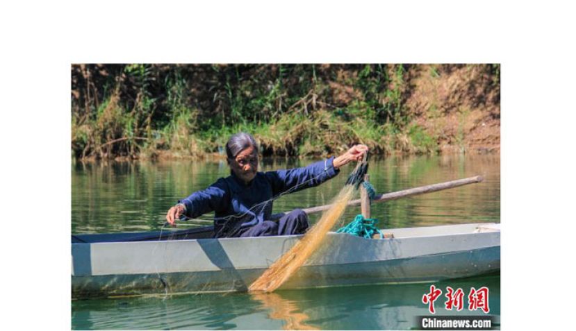 唐二妹在放鱼网。