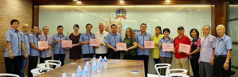 拿督许德忍(中)与众理事移交助学金予获奖学子或代表。