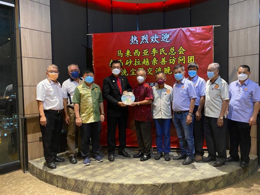 砂拉越陇西公会会长李伟城（右六）在众嘉宾的陪同下，赠送纪念品予马来西亚李氏总会总会长李荣丰（左四），左起为马来西亚李氏总会总秘书李荣华、副总会长拿督李世泉及常务副总会长李赐坚；右起为砂拉越陇西公会财政李永雄、名誉会长李文朥、副会长李剑敏、秘书长彭国良及砂拉越李氏公会署理会长李开生。