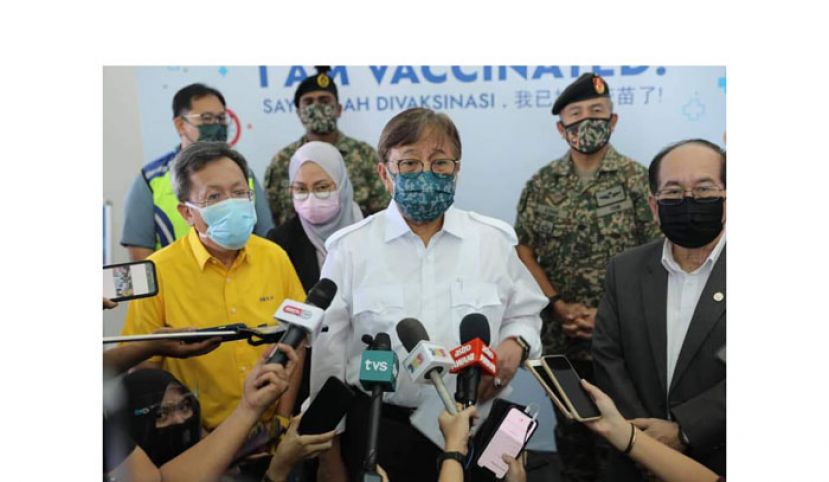 砂首长拿督巴丁宜阿邦佐哈里（中）巡视疫苗接种中心后接受媒体访问。