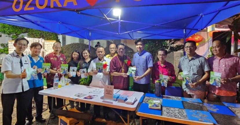 天猛公陈如飞（左7）在甲必丹林传政（左6）等人陪同，由社险柜台服务官员手中接过社险保障资讯；右为拿督龚财兴及本固鲁陈兴枝（右3）；左是薛华东。
