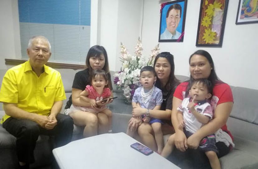 陈超耀(左一)与3名欲装置人工耳蜗的儿童及家长合摄。右起是亚历山大、孙健安和阮彦彤。