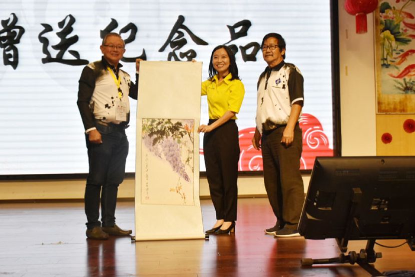 庆典筹委会主席田荣喜（左）与古晋中华书画研究会会长沈捷平（右）赠送纪墨宝给拿督陈超耀的代表许德婉（中）。