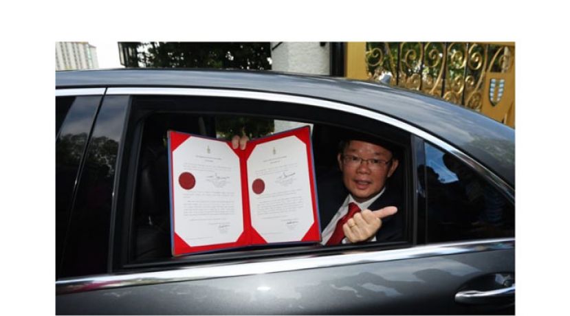 曹观友向媒体展示州元首签署解散州议会的御准令。