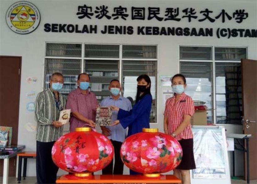 甲必丹林传政（中）与孙守生（左二）及沈云豹（左一）移交古晋老巴刹联谊会出版的《古晋老巴刹历史掌故与生活变迁》书籍及春节灯笼装饰品予实淡宾国民型华文小学校长张秀凤（右二）；右一为罗莉萍老师。