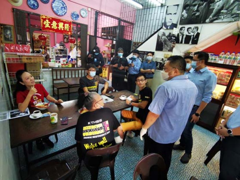 拿督黄黄鸿圣走访浮罗岸老街，提醒民众遵守防疫措施。