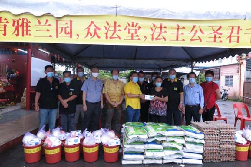 沈桂贤（左6）移交布施品给受惠者。