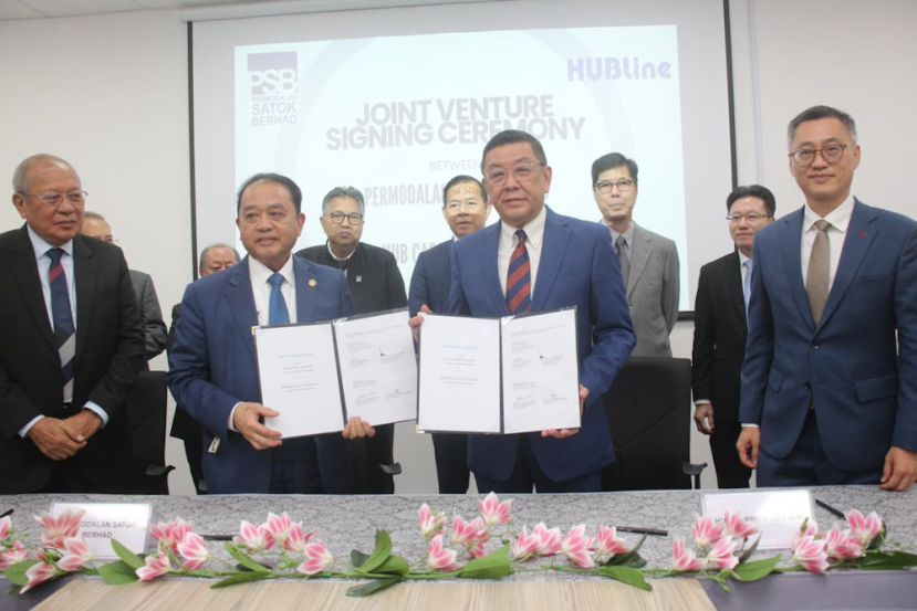 HubLine 集团执行主席拿督斯里黄良杰(前排右二)与PSB 公司执行主席拿督阿玛阿都阿兹(前排前排左二)互相交换签署的合作协议。