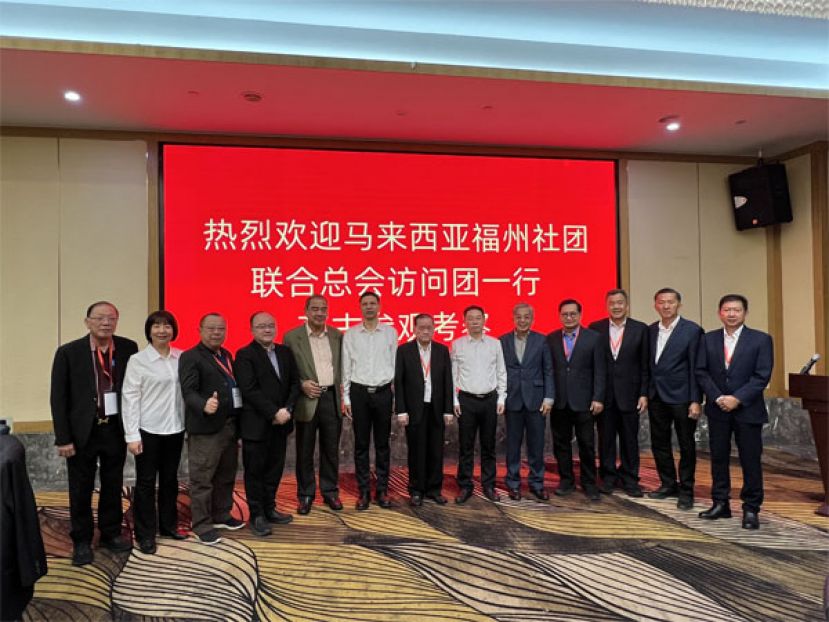 马福领导，包括秘书长刘锦虎（左一）、副交际主任徐孝軾（左三）、副会长甲必丹拿督刘思乐（左四）永久名誉顾问丹斯里江作汉（左五）、马福总会长拿督斯里刘为强太平局绅（左七）、署理会长拿督董仕星（左九起）、马福永久名誉会长拿督吴标生、副会长王立光、副会长夏福利、副文教主任拿督刘泍俊与古田县委书记张成慧、（左八）、古田县长许锋（左六）以及古田县委常委、宣传部长张肖枫（左二）合影于接待晚宴上。